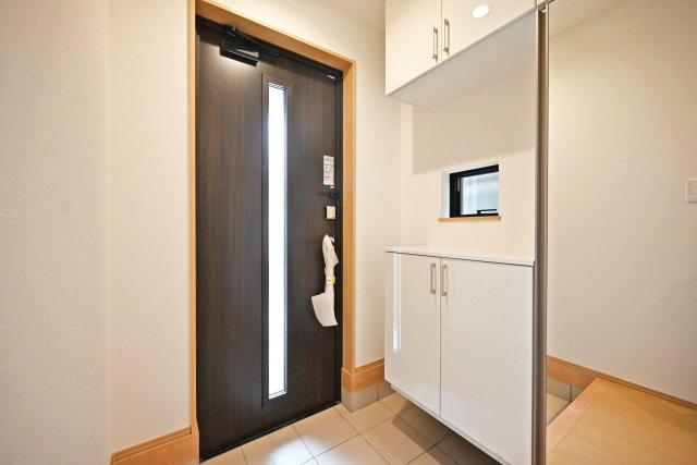 ハートフルタウン伊丹市奥畑2丁目新築一戸建て│3LDK+駐車2台可(車種制限有)の玄関|1階玄関をホール側から撮影した内観写真です。 シンプルな玄関扉にシューズボックス、小窓を配置したオーソドックスな玄関です。