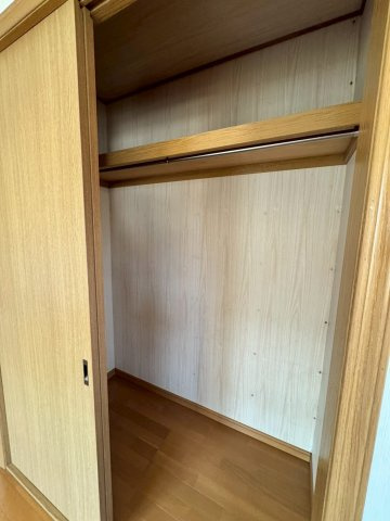 狭山市根岸1丁目中古戸建の収納|ロングコートも折らずに収納できるハンガーパイプを完備。洗濯物を畳む手間を省き、一目で服を選べるため朝の身支度もスムーズです。家具を置かないスッキリとした暮らしを、落ち着いた質感の空間が支えます。
