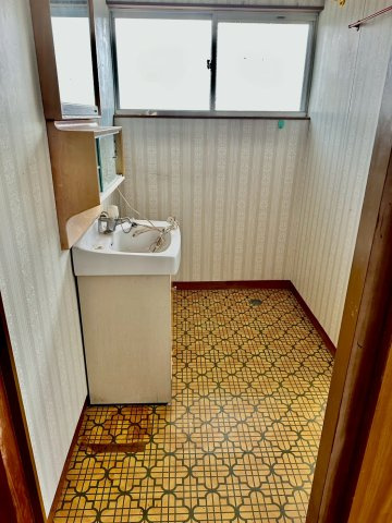 寿町　中古戸建の脱衣所|洗濯機を室内に置けるため、家電の劣化を防ぎ、夜間のお洗濯も気兼ねなく行えます。洗面スペースと隣接しており、脱衣から洗濯までの流れがスムーズ。