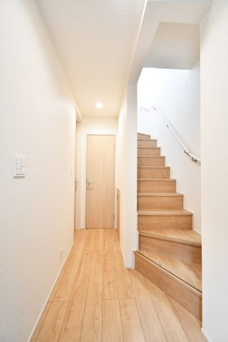 上尾市上　全3棟の玄関|木の温もりが心地よい玄関ホールは、無駄のない動線設計が魅力。明るい階段が家族を2階のLDKへと優しく導きます。採光に配慮した設計で、閉塞感のない清々しい毎日がここから始まります。