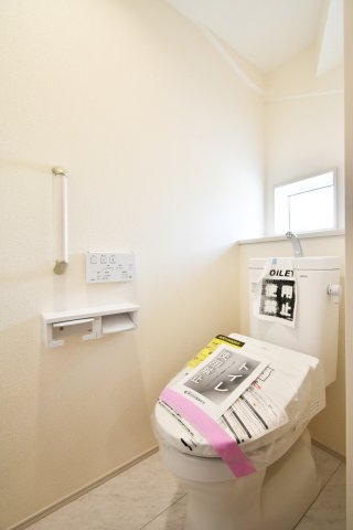 上尾市上　全3棟のトイレ|お掃除のしやすさに配慮した節水型トイレを採用。手すりや便利な棚付きで、家族全員が安心して使えるユニバーサルデザインです。窓からの自然光が、朝の時間を爽やかに演出。