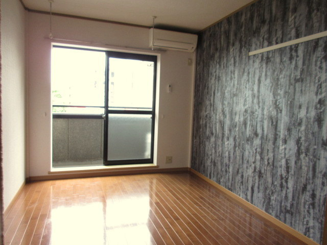 ハイツイラゴの居間・リビング|アクセントクロスがお洒落な洋室　南西向き日当り良好