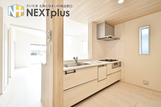 上尾市上　全3棟　2号棟のキッチン|19帖の広々としたLDK全体を見渡せる対面キッチン。木目調の天井がアクセントとなり、平屋ならではの贅沢な空間を演出します。料理中も家族の気配を感じられる、一体感のある設計が魅力です。