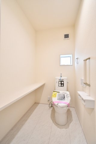 上尾市上　全3棟　2号棟のトイレ|ゆとりある広さを確保したトイレ空間。小窓付きで換気もしやすく、明るく清潔感があります。便利な手すりやちょっとした小物が置けるカウンター付き。毎日の生活に欠かせない場所だからこそ快適さにこだわりました。