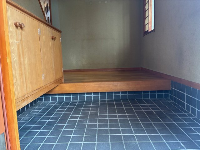桃山台5丁目中古戸建の玄関|玄関はタイル床仕上げで、雨の日のお手入れもスムーズ。大容量の下駄箱が完備されており、ご家族全員の靴をすっきりと収納できます。清潔感のある明るい空間が、住まう人と訪れる人を心地よく迎えてくれる場所です