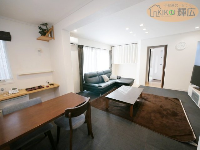 姫路市大塩町汐咲 中古戸建の居間・リビング|ダウンライトが優しく照らす、デザイン性の高いLDKが魅力の物件です。収納力のあるシステムキッチンなど、生活の質を高める設備が充実。