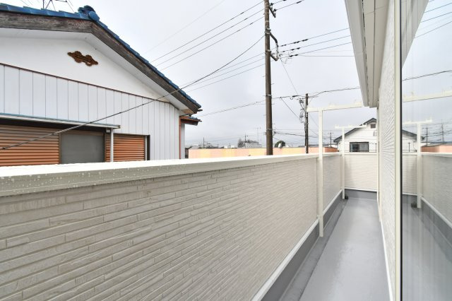 伊奈町本町第3　全2棟　1号棟のバルコニー|陽当り良好な南西向き設計で、お布団や洗濯物もカラッと乾きます。2部屋から出入り可能な便利な動線を採用。周囲に高い建物がなく、心地よい風を感じながら家事を楽しめるゆとりある広さが魅力です。