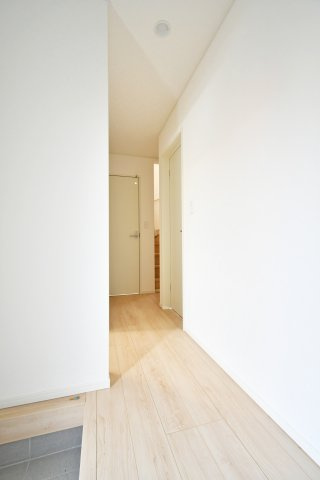 伊奈町本町第3　全2棟　1号棟の玄関|清潔感のあるホワイト壁とナチュラルなフローリングが調和した玄関ホール。奥行きを感じる設計で、帰宅した瞬間に開放感に包まれます。各居室へ繋がる動線もスムーズで、暮らしやすさを予感させる空間です。