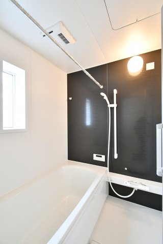 伊奈町本町第3　全2棟　1号棟の浴室|浴室乾燥機付きで雨の日の洗濯も安心なシステムバス。ゆったりとした浴槽で一日の疲れを癒せます。窓があるため、日中は自然光を感じながら開放的な入浴を楽しめる空間です。