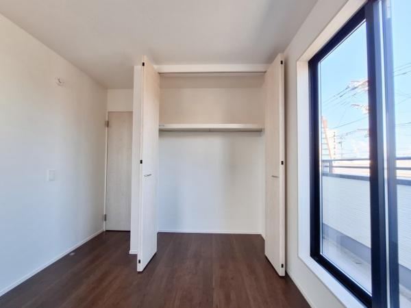 花高松2丁目1期1号棟の玄関|玄関は木目調のドアと明るい収納スペースが調和し清潔感のある空間です。小窓から自然光が差し込み玄関全体が明るくなっています。収納キャビネットも設置されており玄関の使い勝手を高めています。