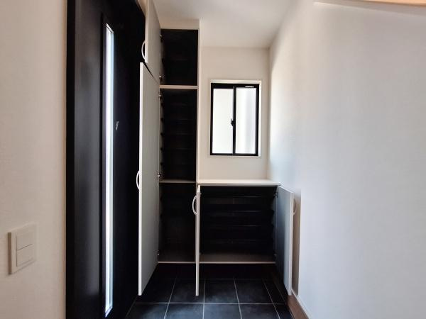 大字佐野1期3号棟の玄関|玄関には収納力のあるシューズボックスが設置されています。窓もあり明るさを確保しています。扉付きの収納なので見た目もすっきりとしています。床はお手入れがしやすい素材です。