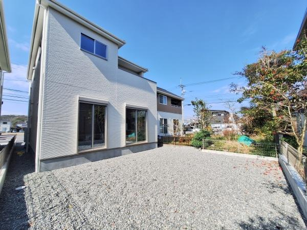 大字佐野1期1号棟の庭|広々とした敷地の庭が印象的です。日当たりの良い空間で解放感を感じられます。シンプルな外観と調和した使いやすい庭です。周囲の建物との距離もしっかり確保されています。