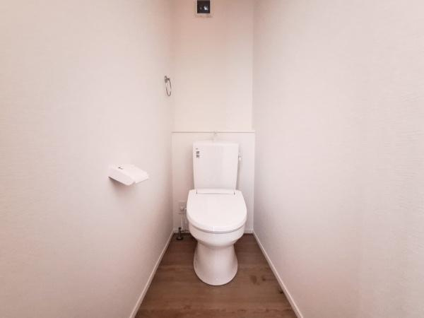 大字佐野1期1号棟のトイレ|シンプルで清潔感のあるトイレ空間です。壁紙と床材の組み合わせが落ち着いた雰囲気を演出しています。余計な装飾がなくすっきりとした印象です。必要な設備が揃っており使い勝手も考慮されています。