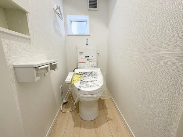 松が丘第1-2号棟のトイレ|清潔感のある明るいトイレ空間です。白を基調とした内装でコンパクトながらもすっきりとした印象です。収納棚やペーパーホルダーも備わっています。小窓が設置されており換気もしやすい仕様です。