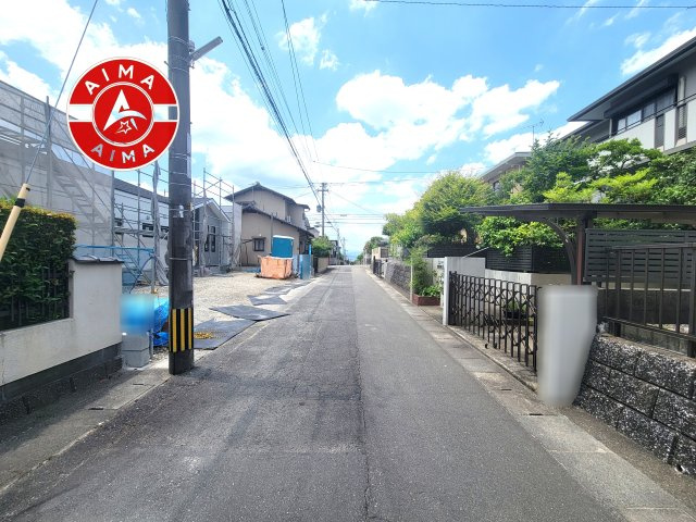 太宰府市青山1丁目第2-1棟(1号棟)の前面道路含む現地写真|前面道路は閑静な住宅地をはしる車通りの少ない道路。お車の出し入れが苦手なママや小さなお子様にも安心ですね。しっかり舗装もされているので、ベビーカーや自転車で通っても快適に通行できます。