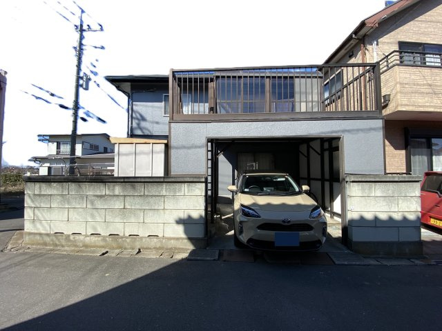 松伏町グループホームOC物件 軽量鉄骨造・一戸建の前面道路含む現地写真|1台分の駐車スペースを確保。上部はバルコニーの設計。