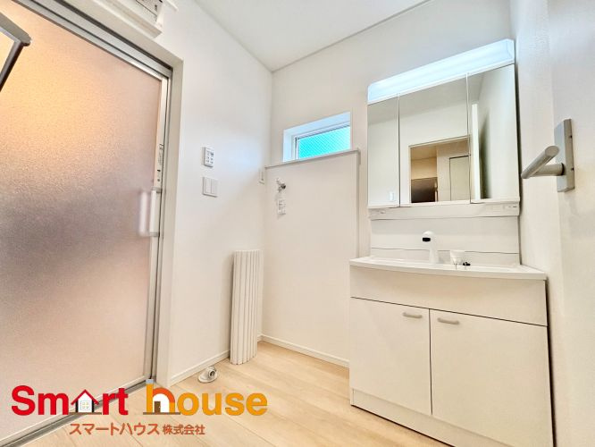 相模原市中央区田名第144　新築2棟の脱衣所|ゆとりの洗面スペースで朝の身支度も快適スムーズに。３面鏡で髪のセットやお化粧もストレスなくこなせ、朝から気分良く通勤通学に向かえそうですね！鏡の裏にはたっぷりと収納スペースを標準装備！