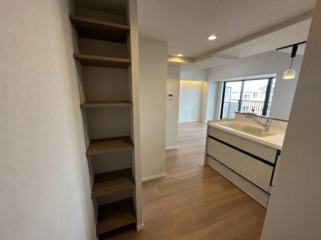 戸塚西パークホームズ壱番館のキッチン|キッチン横のオープン収納です。よく使うスパイスの置き場に良さそうです。