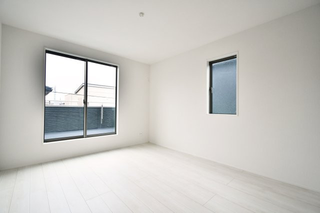 久喜市南7期　全2棟　2号棟の洋室|主寝室におすすめな7帖のゆとりある洋室。南西向きのバルコニーに面しており、明るい光と心地よい風が通り抜けます。白を基調とした内装と木目調の扉が調和し、一日の疲れを癒す落ち着いたプライベート空間を演出。