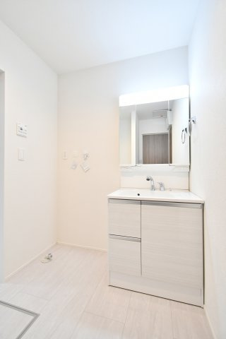 久喜市南7期　全2棟　2号棟の独立洗面台|三面鏡の裏に小物を隠せる、収納力◎のシャワー付洗面化粧台。忙しい朝の身支度もスムーズに。洗面室は「広い洗面室」と資料にもある通り、着替えや家事動線にもゆとりが持てる広々とした空間が魅力です。
