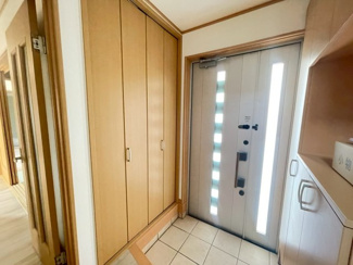 【玄関】 | 千葉市緑区平山町　中古戸建　JR外房線「鎌取駅」 | 天井まで高さのある大型のシューズボックスを備えた、収納力豊富な玄関です。家族全員の靴をすっきり収められるほか、玄関周りの小物も片付きます。木目調の温かみと自然光が差し込む、明るい空間が魅力です。