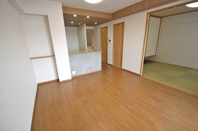 レスタージュ鳳の居間・リビング|リビングの梁部分やキッチンの天井部分には、木目調のアクセントクロスを貼りました。