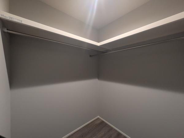 タマタウン横尾東町2　2号地の収納|クローゼット内は余裕のあるスペース設計です。コーナー部分までロッドが伸びていて使い勝手の良さが特徴です。シンプルで落ち着いた内装が印象的です。床は木目調で手入れがしやすい仕様です。