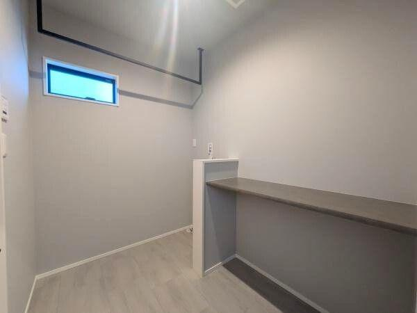 タマタウン横尾東町2　2号地の内装|シンプルな内装が特徴の空間です。使いやすいカウンターが設置されておりシックなカラーで統一されています。高窓から自然光が入りやすく明るさを感じられます。天井のパイプもアクセントになっています。