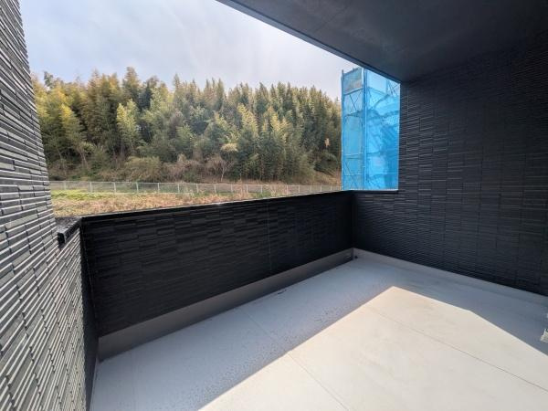 タマタウン横尾東町2　2号地のバルコニー|緑豊かな景色を眺められるバルコニーです。プライバシーに配慮した設計で落ち着いた雰囲気が広がります。広々とした空間が確保され自由なレイアウトも可能です。外部からの視線を遮る壁面もポイントです。