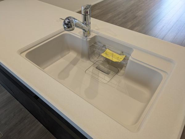 タマタウン横尾東町2　2号地のキッチン|シンプルですっきりとしたデザインのキッチンシンクです。広めのシンクスペースで作業がしやすそうです。程よい高さの水栓が設置されています。シンク内には便利なラックも付属しています。