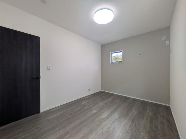 タマタウン横尾東町2　2号地の洋室|落ち着いた色合いのフローリングが印象的な洋室です。天井照明が室内を明るく照らします。シンプルな内装でお手入れもしやすい空間です。小窓から自然光が入り室内が明るく感じられます。