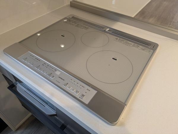 タマタウン横尾東町2　2号地のキッチン|操作パネルが見やすいIHクッキングヒーターが設置されています。シンプルなデザインがキッチン全体と調和しています。表面がフラットなのでお手入れも快適に行えます。三口タイプで調理の幅も広がります。