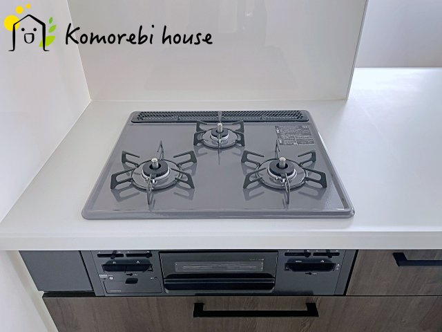 桶川市神明　1期　新築一戸建て　テラシエ　01のキッチン|同時調理が叶う3口コンロと便利なグリル付き。忙しい朝のお弁当作りも、夕食の複数メニューもスムーズにこなせる頼れる設備です。