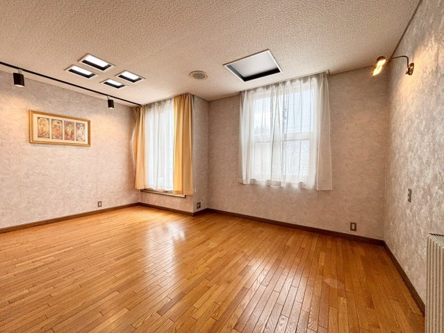 旭ヶ丘３丁目　戸建の洋室|約12帖のゆとりある洋室。スポットライトが壁面を美しく照らし、アートやインテリアが映える上質な洋室