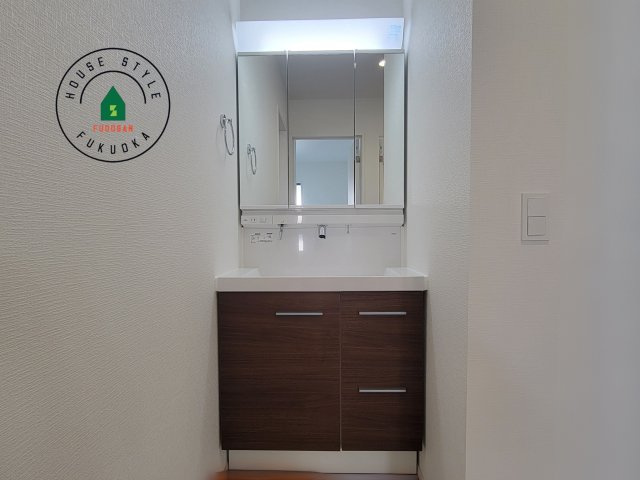 太宰府市梅ヶ丘1丁目第3-2棟（1号棟）の内観：施工例|毎日使うものだから清潔な空間を保ちたい水回り。洗面にはそんな願いを解消させてくれる収納アイデアが満載です。三面鏡の裏側にはキャビネットが現れ小物から背の高い物まで収納できます。