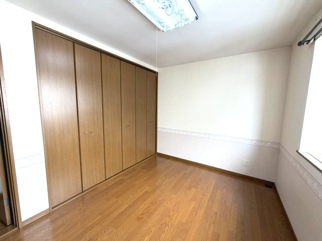 北見市東三輪５丁目５番地４９　中古売家 外１筆の洋室|通常のクローゼットの奥行きは60cm程度が一般的ですが、90cmの奥行きがあることで、奥に収納ケース、手前にハンガー掛けなど、前後で使い分けが可能になり、畳んだ衣類や小物も収納しやすいです。

