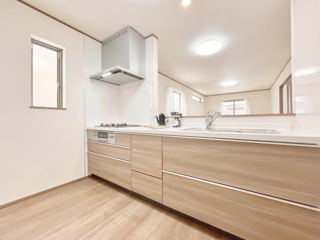 草加市瀬崎７丁目　新築分譲　全８邸のキッチン|【システムキッチン】豊富な収納はもちろん、大型シンクに３口グリル付きコンロ・浄水器など使いやすさ重視の対面式システムキッチン。ご家族と楽しく会話をしながら料理もできます♪