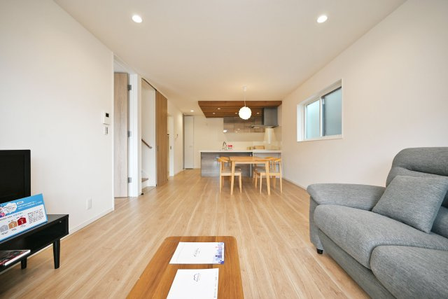 マドレコート宝塚市宝梅2丁目新築一戸建て｜4LDK＋駐車2台の居間・リビング|リビング側からキッチンに向かって撮影した写真です。キッチンでお料理している様子が見えるので、今日の学校での出来事や仕事のことなど、家族間の会話が途切れないのが◎