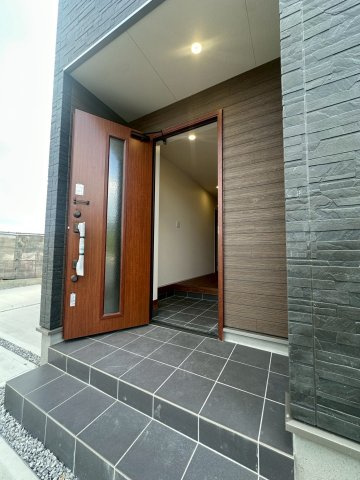 リーブルガーデンうるま市高江洲・２号棟の玄関|自然光が差し込む玄関ドア／屋根付きの玄関ポーチで、置き配も◎