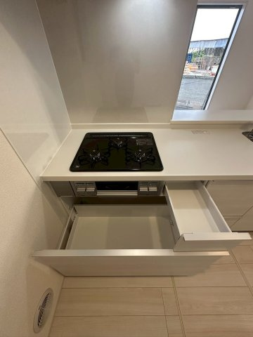 リーブルガーデンうるま市高江洲・３号棟のキッチン|ガスコンロ３口下にも備え付けの収納◎