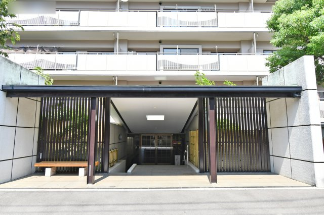 ルネ大宮パークステイツのエントランス|落ち着きある和モダンなアプローチ。屋根付きの設計は雨の日の出入りをスムーズにし、住まう方を優雅に迎え入れます。日勤管理による整えられた空間が、建物の質の高さを物語っています。