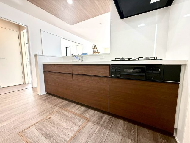 グラファーレ南城市知念安座真３期・３号棟のキッチン|レンジフード＆ガスコンロ３口＆流し台＆備え付け収納付きのキッチン