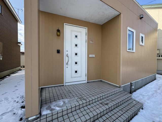 陽光注ぐモダン邸宅。昭和中央の利便性と60坪の開放感を楽しむゆとりの家♪の玄関|白いデザインドアがアクセント。木目調外壁に映えるモダンな玄関