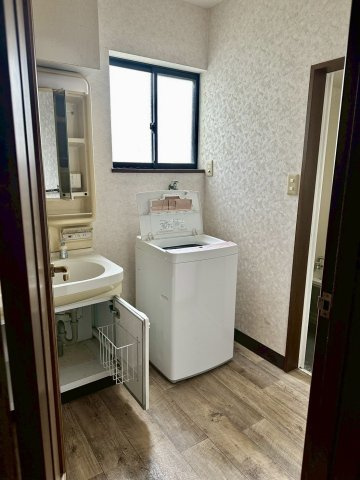 又野3丁目　中古戸建の洗面所|独立洗面台を完備しており、朝の身支度や洗顔がスムーズに行える環境です。室内洗濯機置場も隣接しているため、脱いだ服をすぐに洗える効率的な家事動線を実現しています。