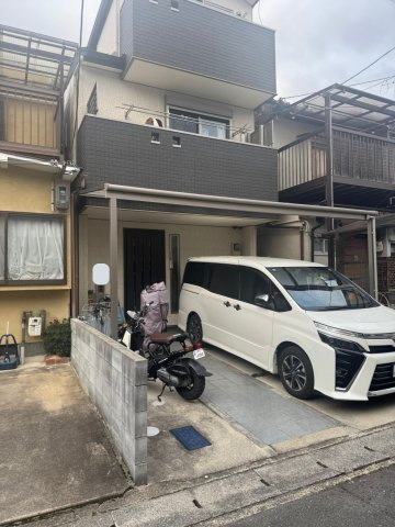 太秦西蜂岡町 中古戸建の外観|カーポート付き駐車スペースのある3階建て住宅。前面道路は落ち着いた住宅街です。