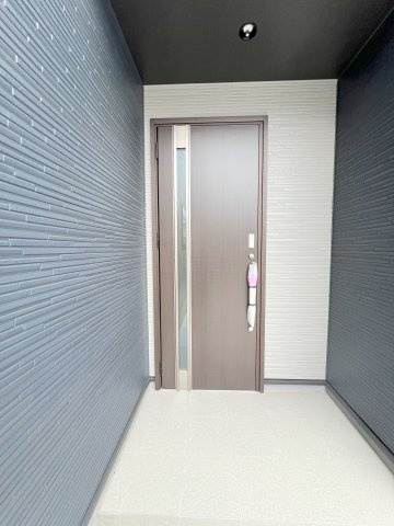 青梅市末広町1丁目　新築戸建全2棟の玄関|奥行きのある玄関ポーチを採用。雨の日も出入りしやすく、落ち着きのある上質な玄関空間が住まいの第一印象を演出します。