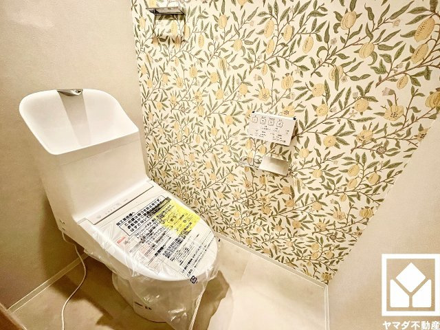 日興甲東園スカイマンションのトイレ|遊び心のあるアクセントクロスが魅力的なトイレ空間。機能性とセンスが融合した、居心地の良いプライベートスペースです。