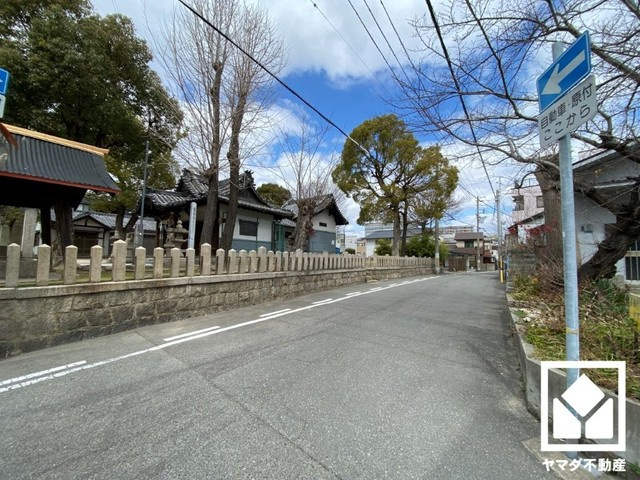 尼崎市金楽寺　1号地の前面道路含む現地写真|西側が駐車場で抜けており、その先は道路なので開放感があります。陽当たり・風通しの良い立地です。