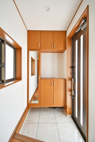 さいたま市見沼区深作2丁目の玄関|収納力豊富なシューズボックスと、姿見鏡が嬉しい玄関。窓からの自然光が明るく開放的な空間を演出します。令和8年1月完成のリフォームで、床タイルも一新。清潔感あふれる「家の顔」がお客様を優しく迎えます。