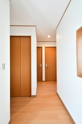 さいたま市見沼区深作2丁目の玄関|温かみのある木目調のフローリングと建具が調和した、落ち着きある廊下空間。全室の壁・天井クロスを貼り替え、清潔感のある心地よさを実現しました。細部までこだわり抜いたリノベーションの質感をぜひ現地で。